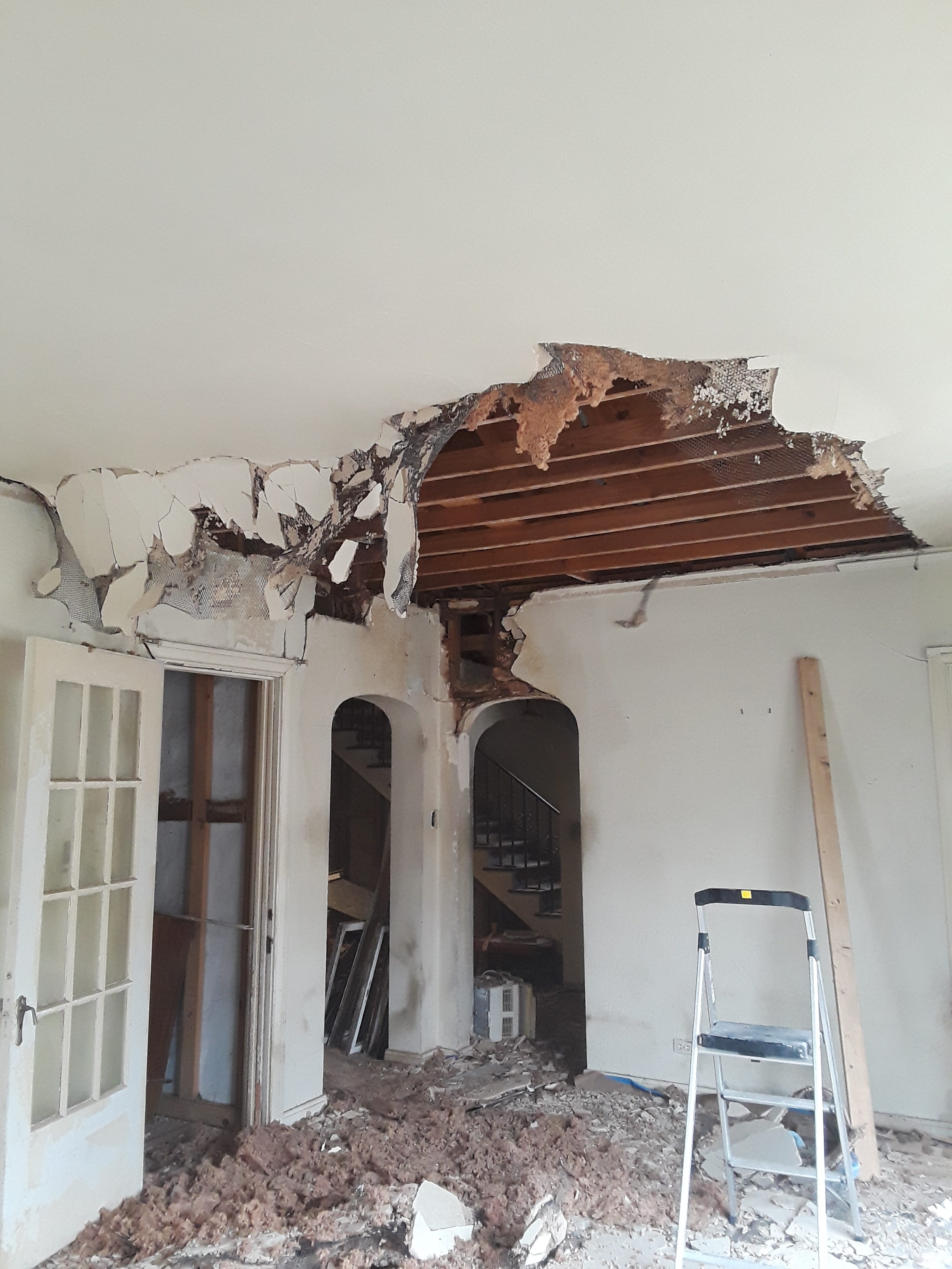 living room with stucco falling down from roof leak